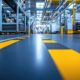 Bodenmarkierung in gelb-schwarz zur Trennung von Lauf- und Fahrwegen in der Industriehalle