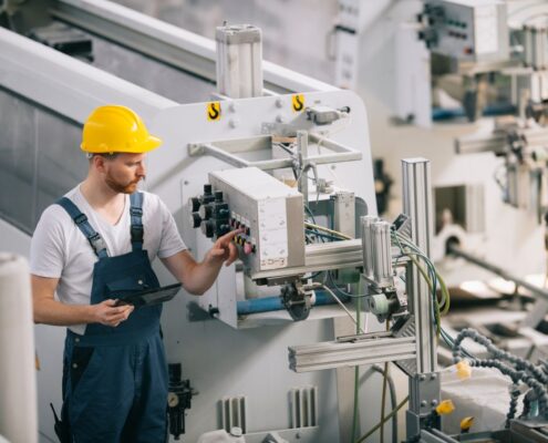 Industriemechaniker prüft Schaltung an moderner Anlage – der korrekte Anschluss am Motorklemmbrett ist entscheidend für einen störungsfreien Betrieb.