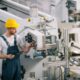 Industriemechaniker prüft Schaltung an moderner Anlage – der korrekte Anschluss am Motorklemmbrett ist entscheidend für einen störungsfreien Betrieb.