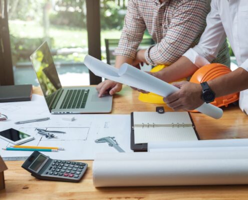 Zwei Fachleute besprechen technische Pläne an einem modernen Arbeitsplatz – Symbolbild für industrielle Präzision und Projektplanung.