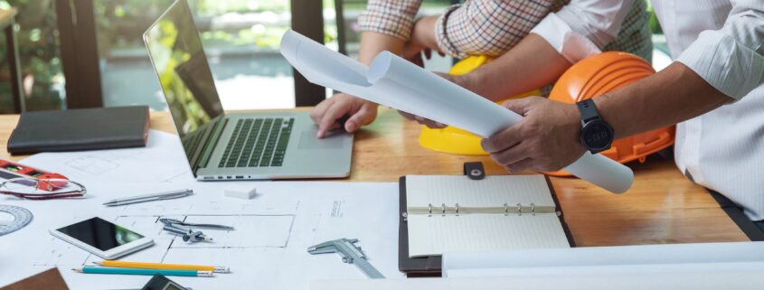 Zwei Fachleute besprechen technische Pläne an einem modernen Arbeitsplatz – Symbolbild für industrielle Präzision und Projektplanung.