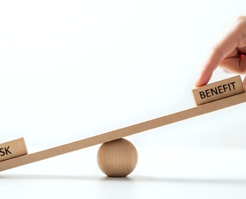 Hand bewegt Holzwaage mit Risk und Benefit | Gebäudereinigung