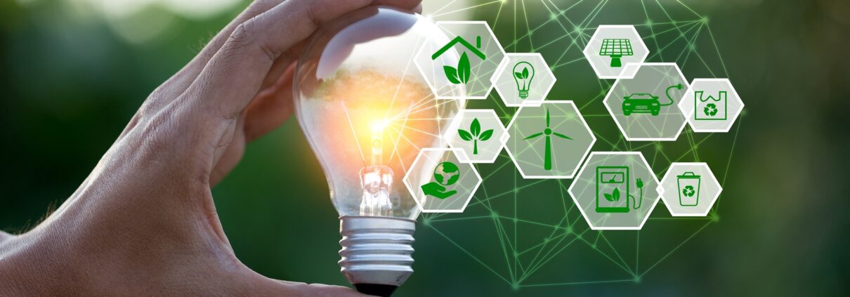 Hand hält Glühbirne mit Symbolen für grüne Energie | Heizölpreise NRW