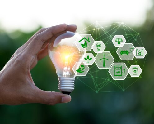 Hand hält Glühbirne mit Symbolen für grüne Energie | Heizölpreise NRW